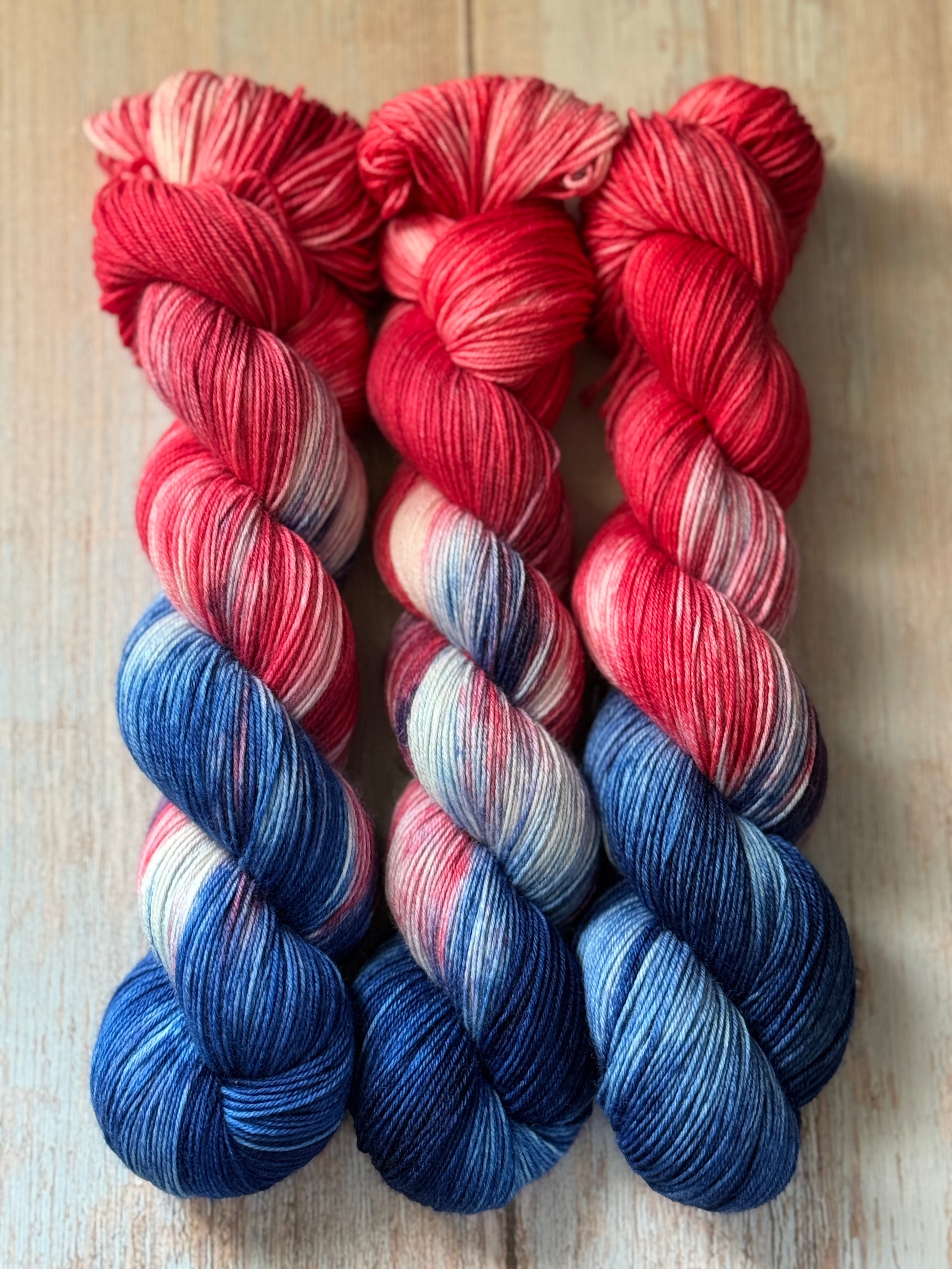 three skeins of red, white and blue yarn