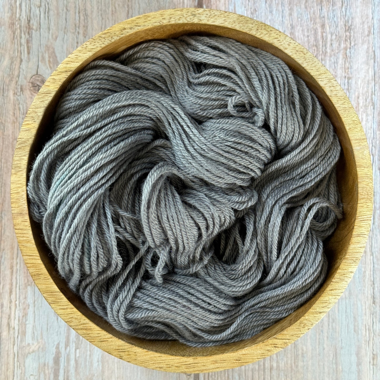 Grey yarn in a wood bowl