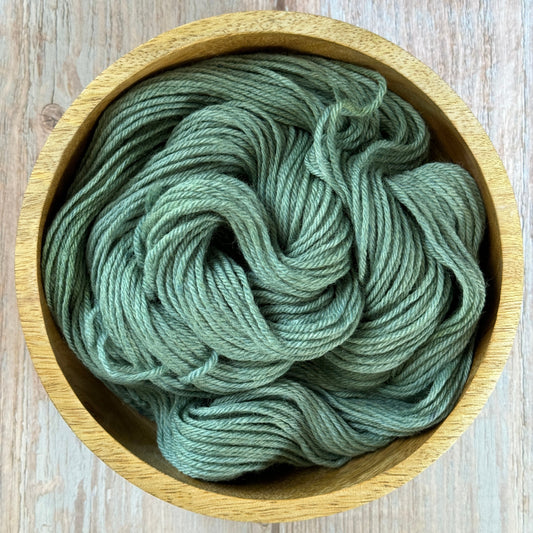 Green yarn in a wood bowl