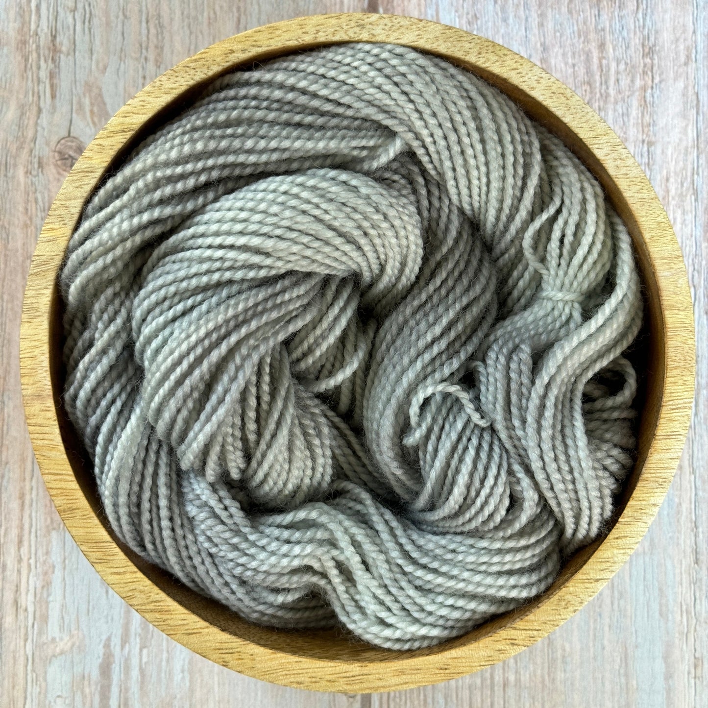 Grey yarn in a wood bowl