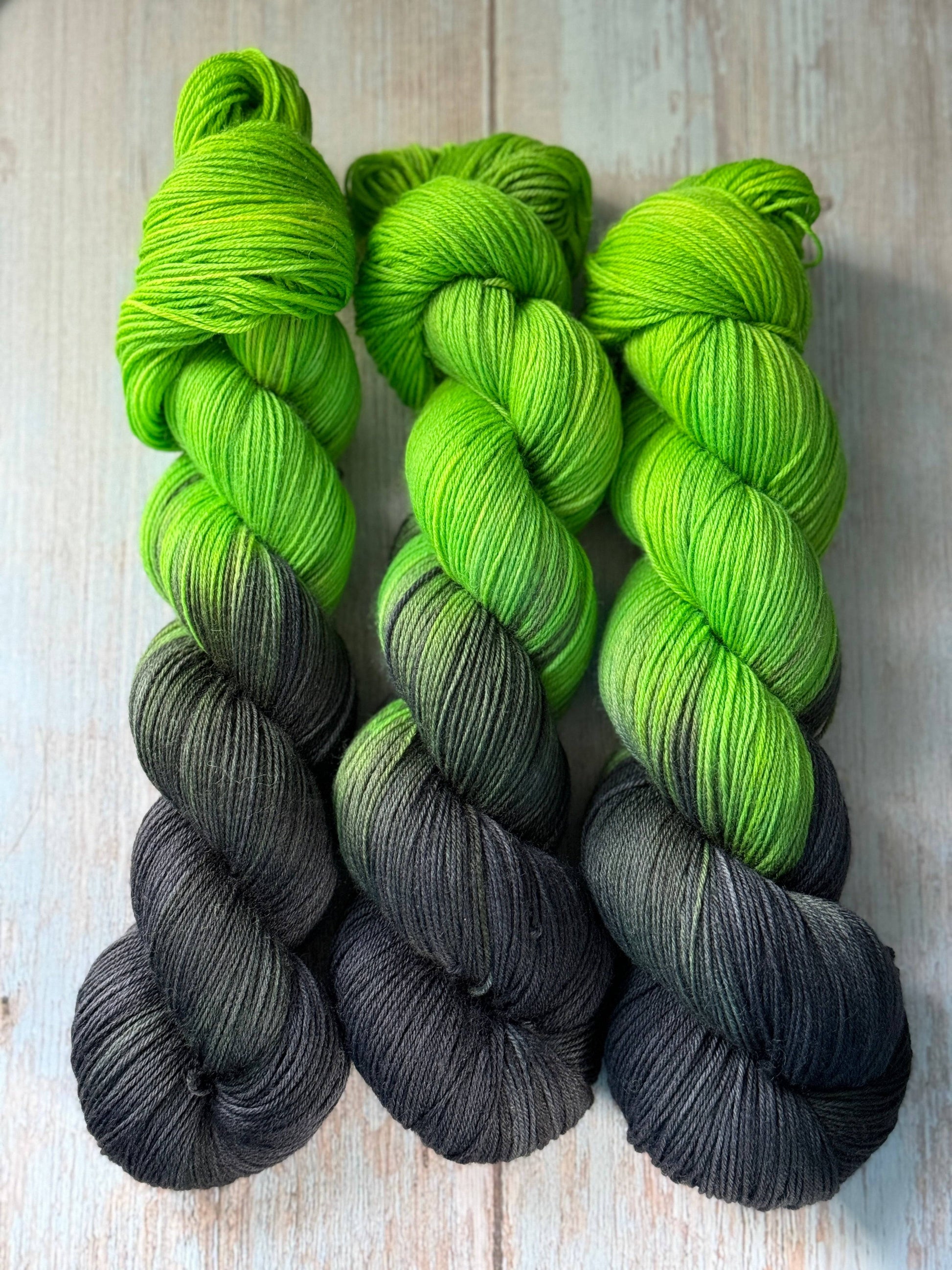 three skeins of green and black yarn