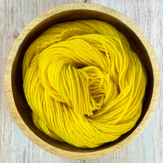 Yellow yarn in a wooden bowl