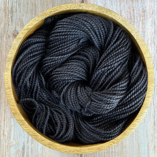 Black yarn in a wood bowl