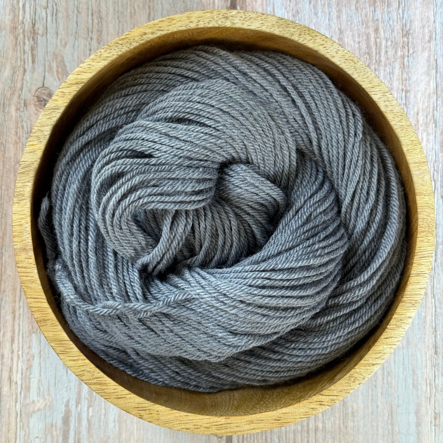 Grey yarn in a wood bowl