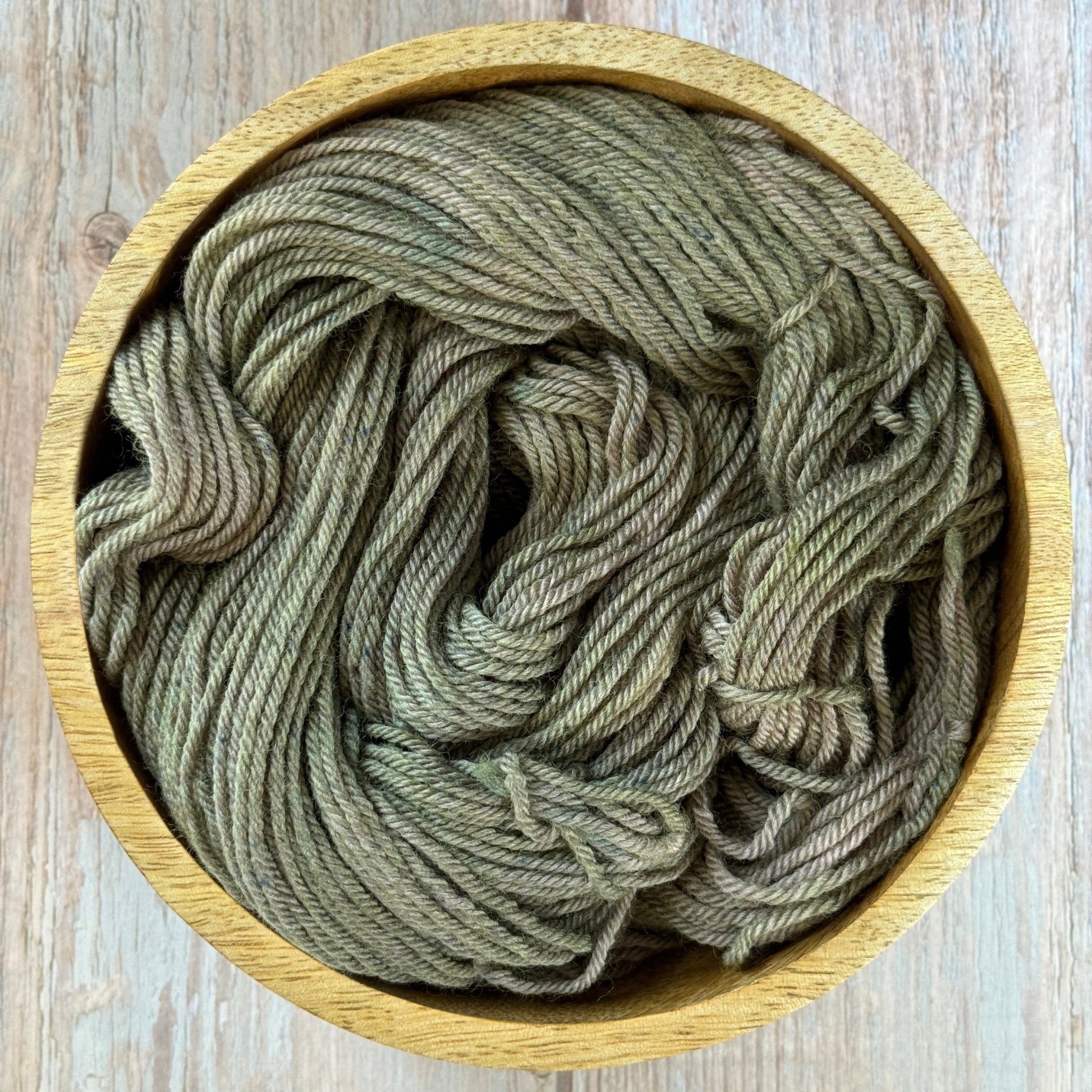 Green yarn in a wood bowl