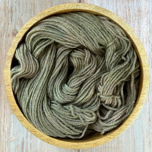 Green yarn in a wood bowl