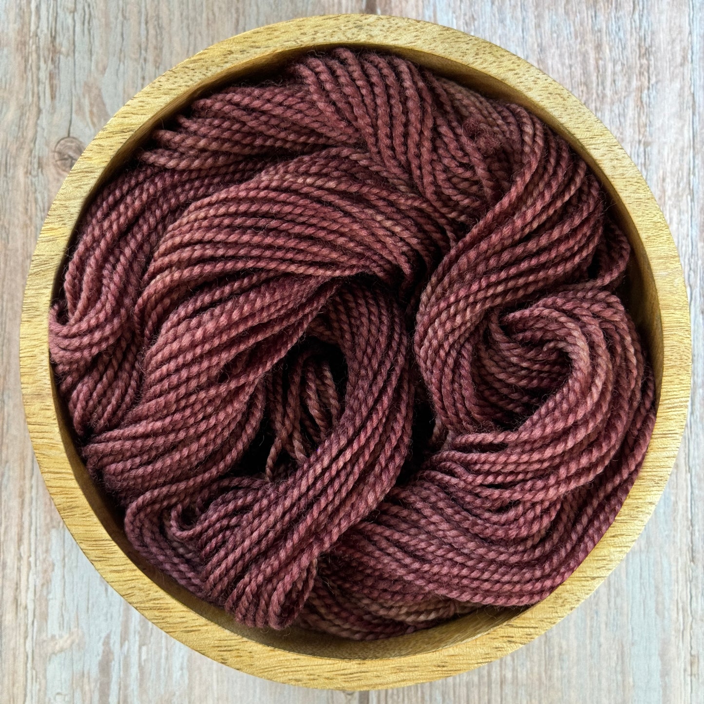 Brown yarn in a wooden bowl